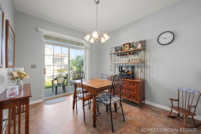 dining space featuring a chandelier and baseboards