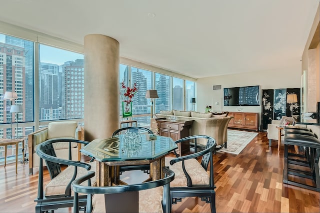 dining room with floor to ceiling windows, wood-type flooring, and a wealth of natural light