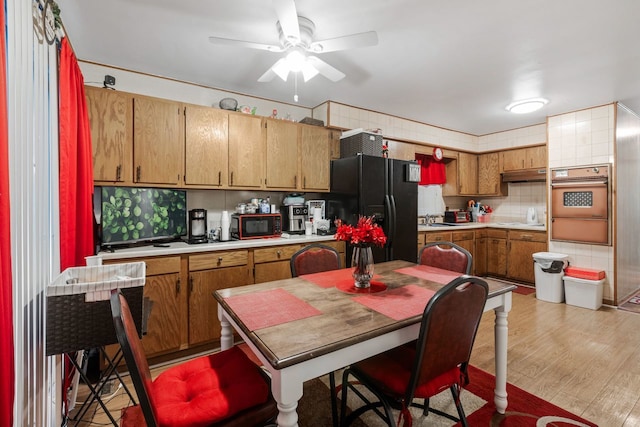 kitchen featuring light hardwood / wood-style floors, tasteful backsplash, sink, black appliances, and ceiling fan