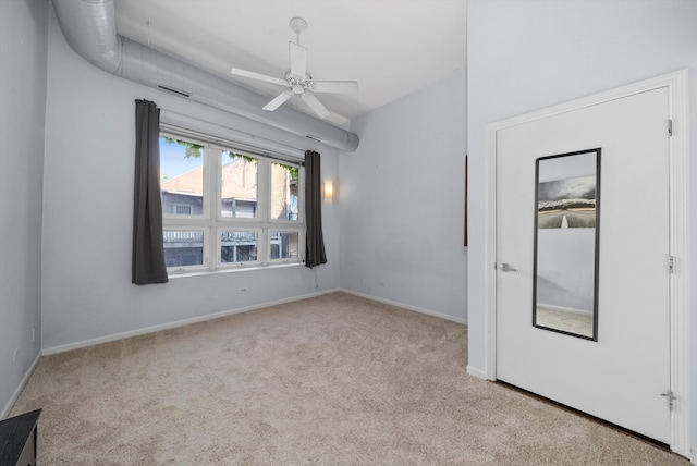 spare room with ceiling fan and light carpet