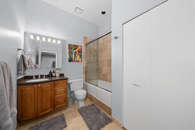 full bathroom featuring shower / bath combination with glass door, tile patterned flooring, toilet, and vanity