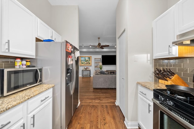 kitchen featuring appliances with stainless steel finishes, white cabinetry, dark hardwood / wood-style flooring, and ceiling fan