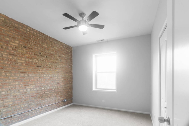 unfurnished room with brick wall, ceiling fan, and carpet floors