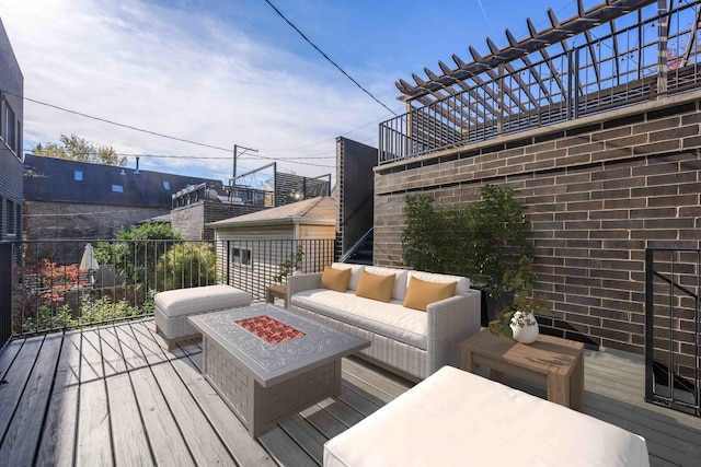 wooden terrace featuring an outdoor living space with a fire pit