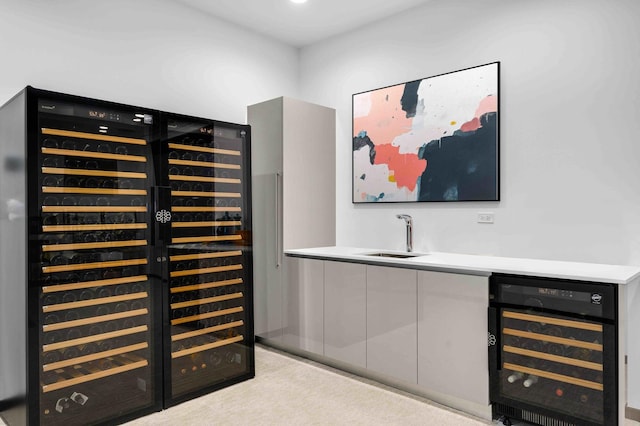 bar featuring wine cooler, sink, and light carpet