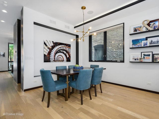 dining space featuring an inviting chandelier and light wood-type flooring