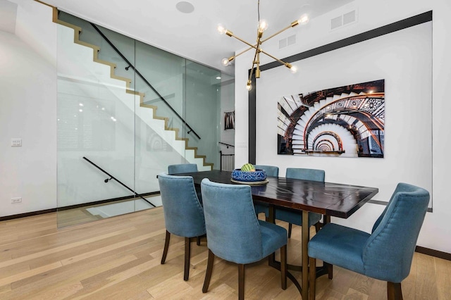 dining space featuring hardwood / wood-style flooring and a chandelier