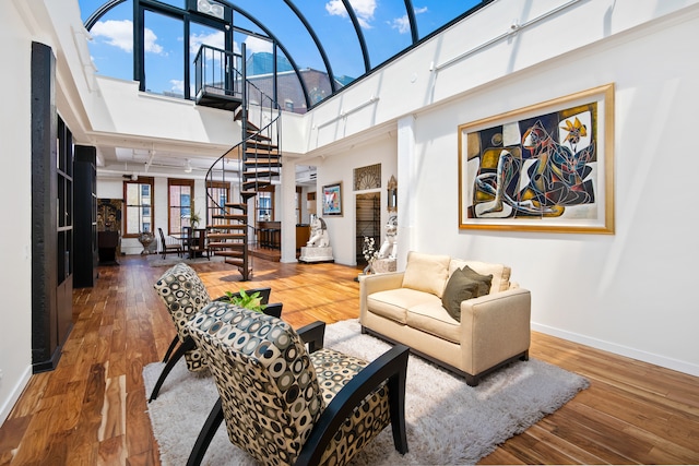 living room with hardwood / wood-style flooring, a high ceiling, and a healthy amount of sunlight