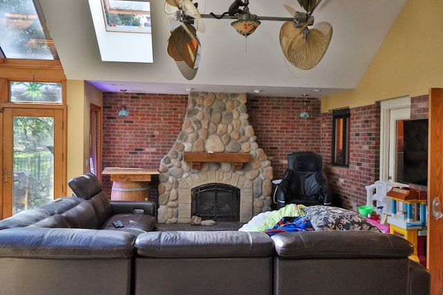 living room with brick wall, a fireplace, and lofted ceiling with skylight