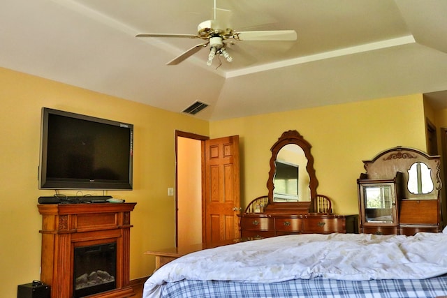 bedroom with ceiling fan, a raised ceiling, and vaulted ceiling