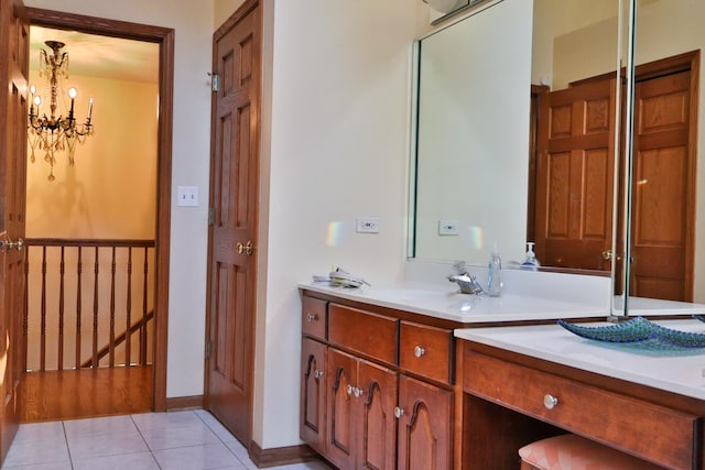 bathroom with a notable chandelier, tile patterned floors, and vanity