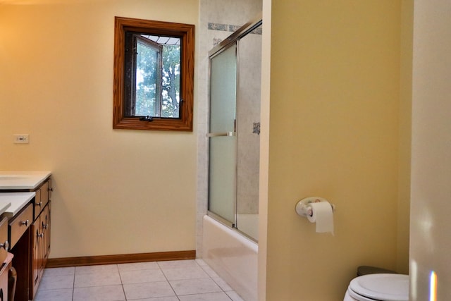 full bathroom featuring tile patterned flooring, bath / shower combo with glass door, vanity, and toilet