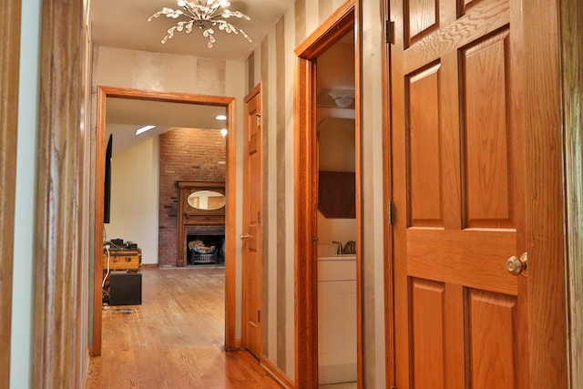 hallway featuring light hardwood / wood-style flooring and a notable chandelier