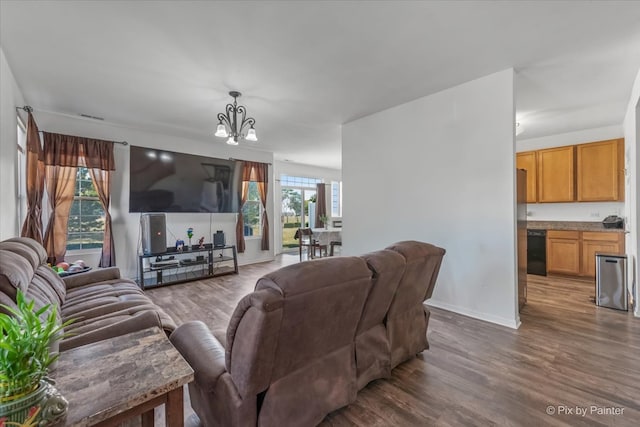 living room featuring a healthy amount of sunlight, a chandelier, and dark hardwood / wood-style floors