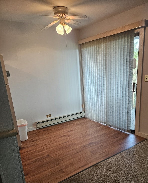 spare room with a baseboard radiator, dark hardwood / wood-style flooring, and ceiling fan