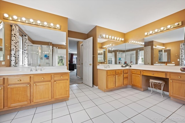 bathroom with a shower with door, vanity, and tile patterned flooring