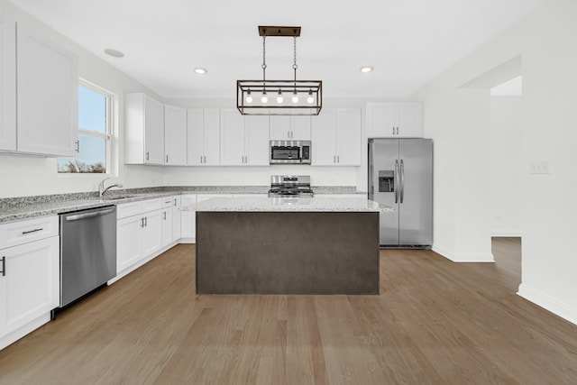 kitchen with white cabinets, stainless steel appliances, dark hardwood / wood-style floors, pendant lighting, and a kitchen island