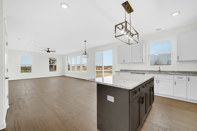 kitchen with ceiling fan with notable chandelier, hanging light fixtures, and white cabinetry