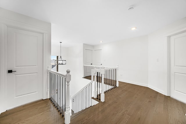 corridor featuring a notable chandelier and hardwood / wood-style flooring