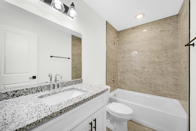 full bathroom featuring toilet, tiled shower / bath combo, and vanity