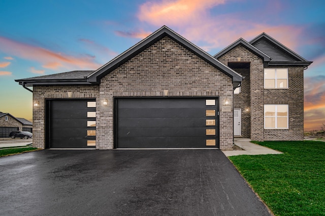 view of front of home with a garage and a lawn