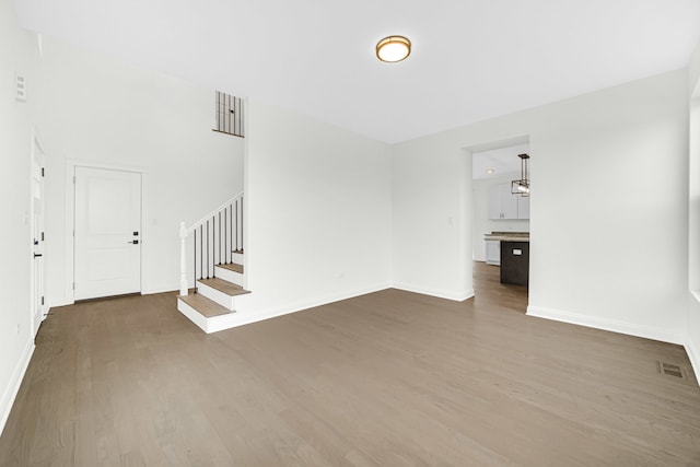 unfurnished living room with dark hardwood / wood-style floors