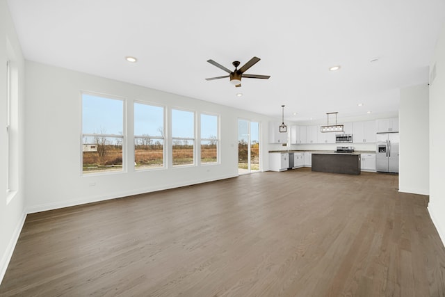 unfurnished living room featuring hardwood / wood-style floors and ceiling fan