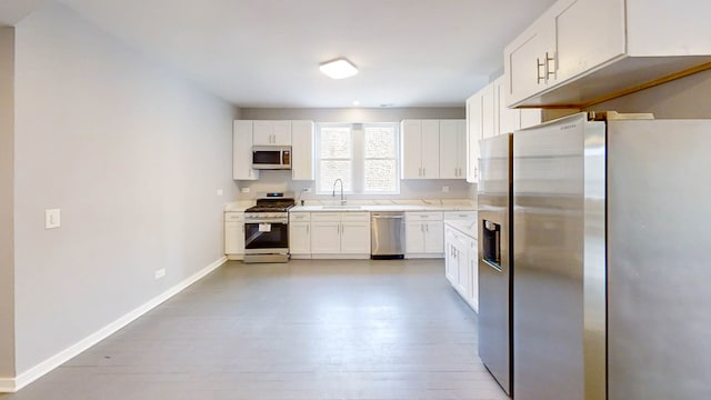 kitchen with light hardwood / wood-style flooring, stainless steel appliances, and white cabinetry