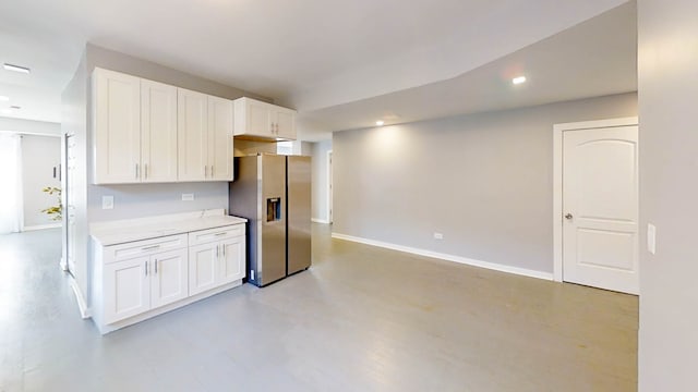 kitchen featuring white cabinets and stainless steel refrigerator with ice dispenser