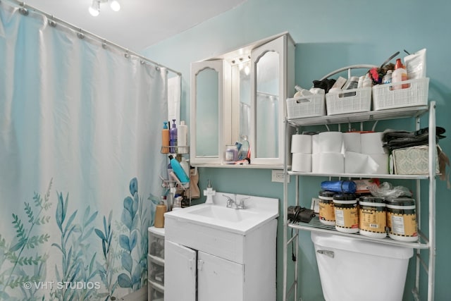 bathroom with walk in shower, vanity, and toilet