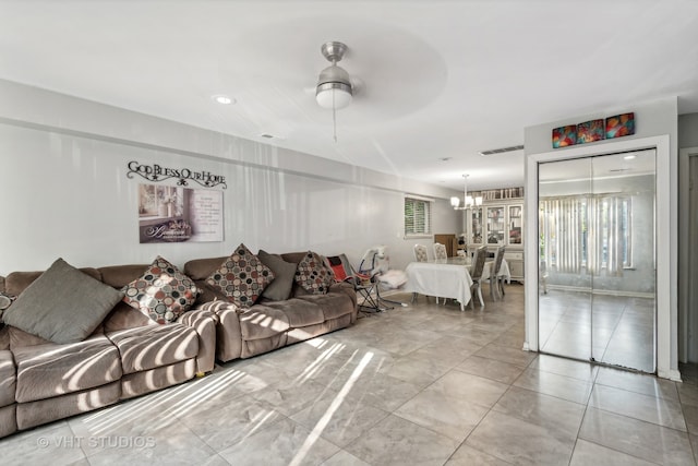 living room with ceiling fan with notable chandelier