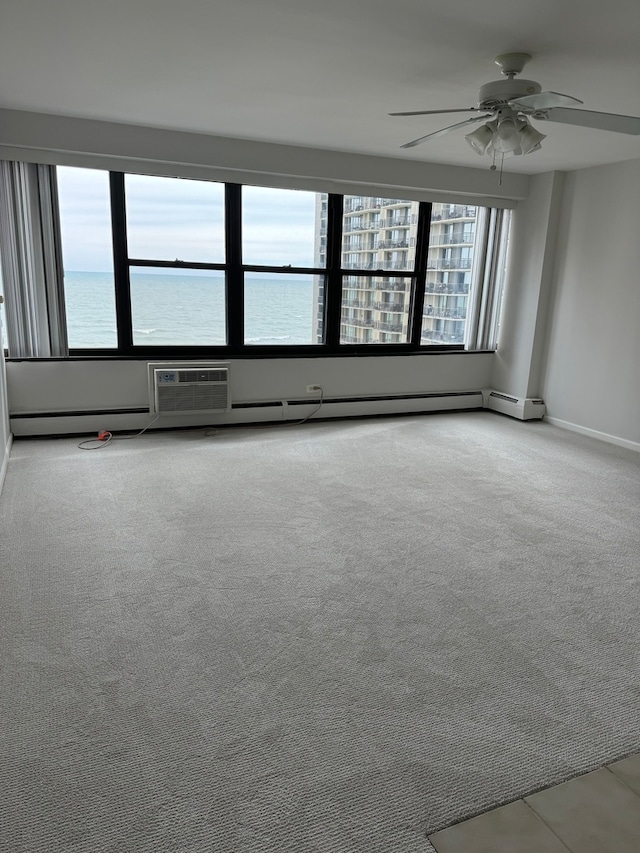 carpeted spare room with ceiling fan and a water view