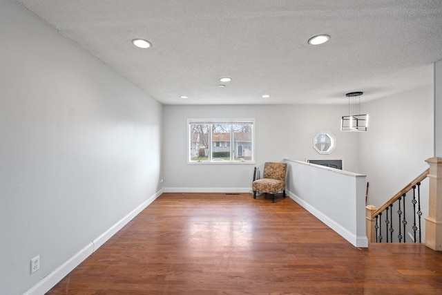 unfurnished room with a textured ceiling and hardwood / wood-style floors