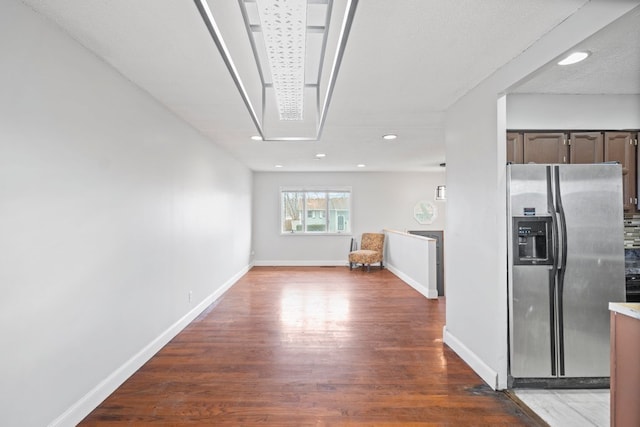 interior space with a textured ceiling, dark hardwood / wood-style flooring, dark brown cabinetry, and stainless steel fridge with ice dispenser