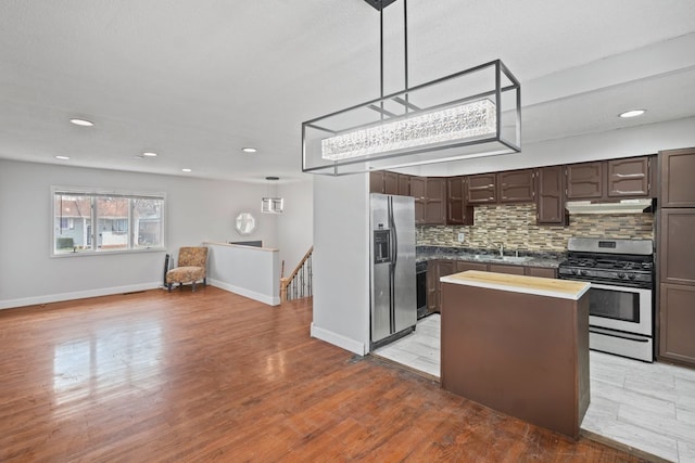 kitchen featuring a center island, light hardwood / wood-style flooring, appliances with stainless steel finishes, sink, and dark brown cabinetry