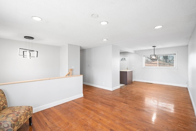 interior space with a textured ceiling and hardwood / wood-style floors