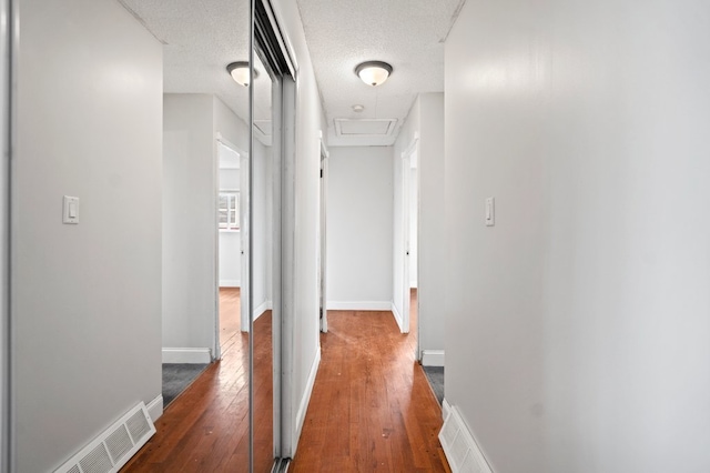 corridor featuring dark wood-type flooring and a textured ceiling