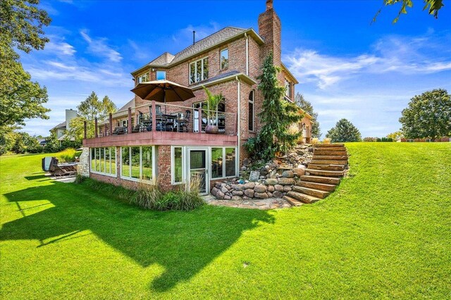 back of property featuring a yard and a hot tub