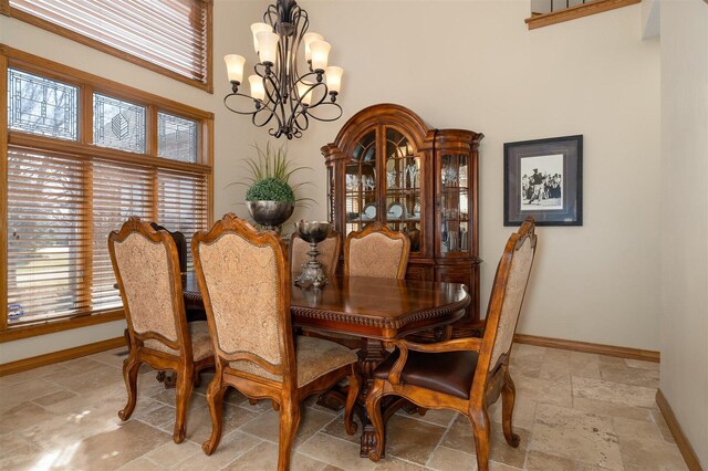 kitchen with decorative light fixtures, appliances with stainless steel finishes, light stone countertops, dark hardwood / wood-style flooring, and a kitchen island with sink