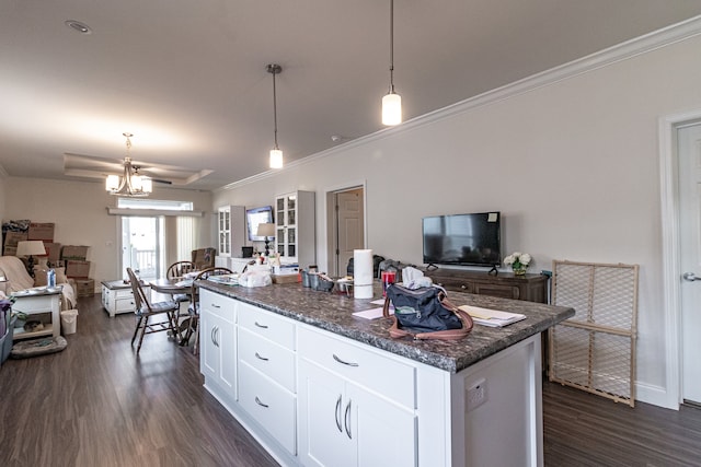 kitchen with pendant lighting, crown molding, a kitchen island, dark wood-type flooring, and white cabinets