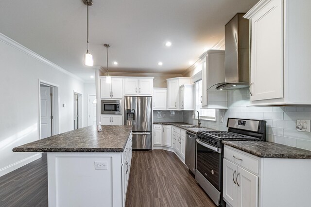 kitchen featuring wall chimney range hood, white cabinets, appliances with stainless steel finishes, and sink