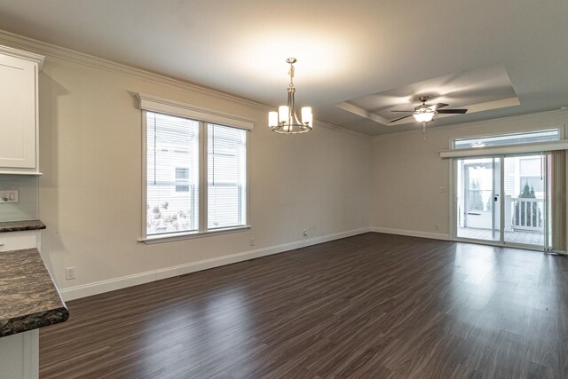 dining area with ceiling fan with notable chandelier, ornamental molding, a tray ceiling, and dark hardwood / wood-style floors