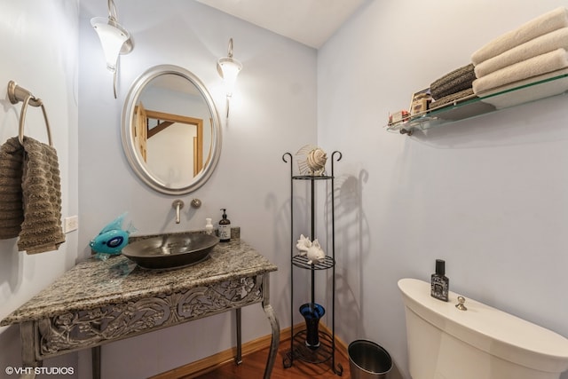 bathroom featuring toilet, sink, and wood-type flooring