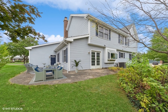 rear view of house featuring central air condition unit, a yard, and a patio