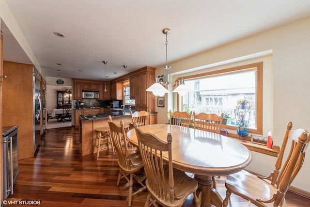 dining space with a healthy amount of sunlight, sink, and dark wood-type flooring