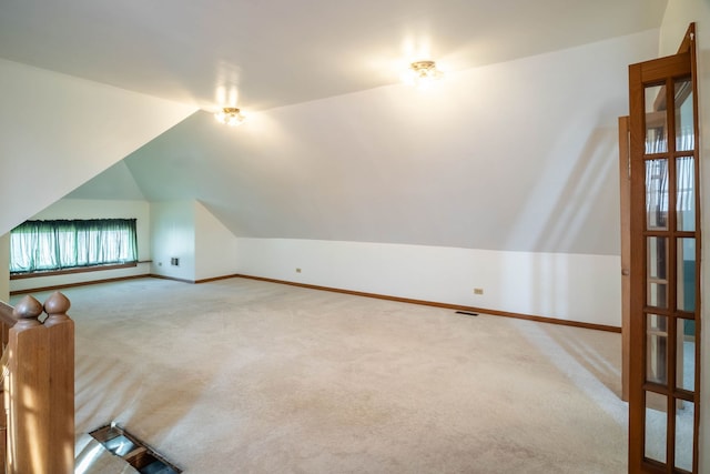 additional living space with carpet flooring and vaulted ceiling