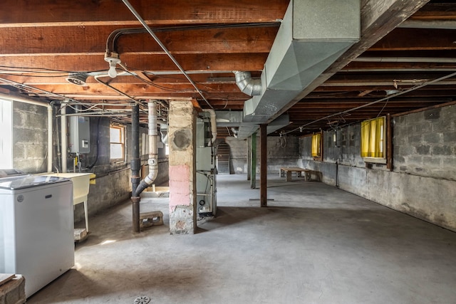 basement with washer / dryer, heating unit, electric panel, and sink