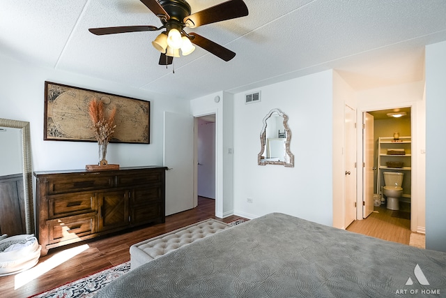 bedroom featuring connected bathroom, a textured ceiling, hardwood / wood-style floors, and ceiling fan