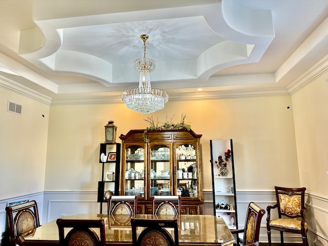 dining room with a tray ceiling, ornamental molding, and a chandelier