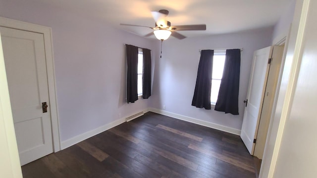 617 E Morgan St, Dixon, IL 61021 - unfurnished bedroom with dark wood finished floors, baseboards, ceiling fan, and baseboard heating